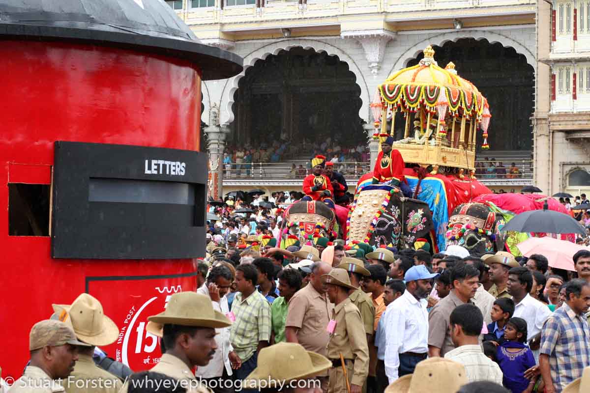 Caparisoned elephants stand at the Dasara procession in Mysore, India. A model of a letterbox is pulled. The procession starts from the Amba Vilas Palace (also known as Mysore Palace) on the tenth and final day of the Dasara Festival. The Procession led by an elephant carrying a golden howdah winds through the streets of the city and ends at Banni Mantap. Groups of performers, musicians and artists from around Karnataka participate in the celebration. The Dasara festivities can be traced back to the Puranas. The very first Dasara in the history of Mysore state can be traced back to the Mahnavami of the Raja Wadiyar in 1610, celebrated at Sriranapatnam. The celebrations honour the victory of the Hindu godess Chamundeswari over the buffalo headed demon Mahishasura.