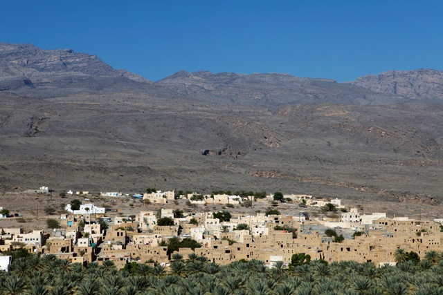 The red, earth coloured houses of the Omani village of Al Hamra. Al Hamra, close to Nizwa, has no defences and is surrounded by lush plantations, thanks to a system of "falaj" irrigation canals