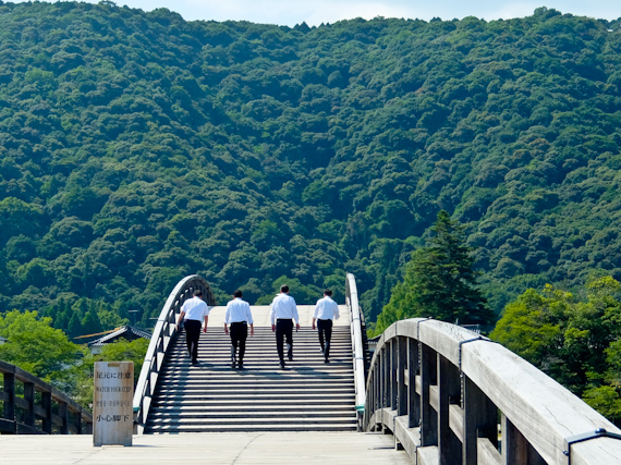 Japanese men crossing Kintai Bridge